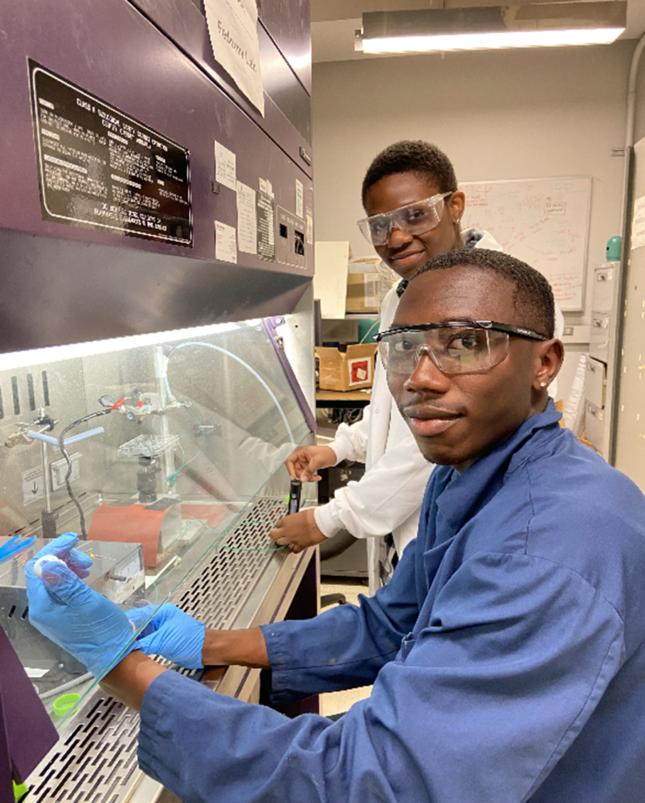 Malik McRae (front) and Ire Adaramola (back) are conducting experiments with the early prototype of the PAINT device for "direct-write" guided drug delivery to biological cells.