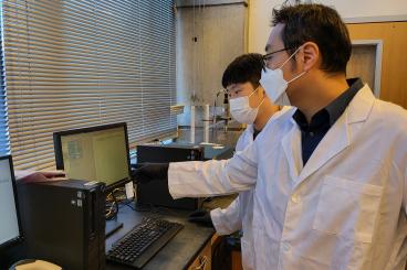 Lee in his lab looking at a computer monitor